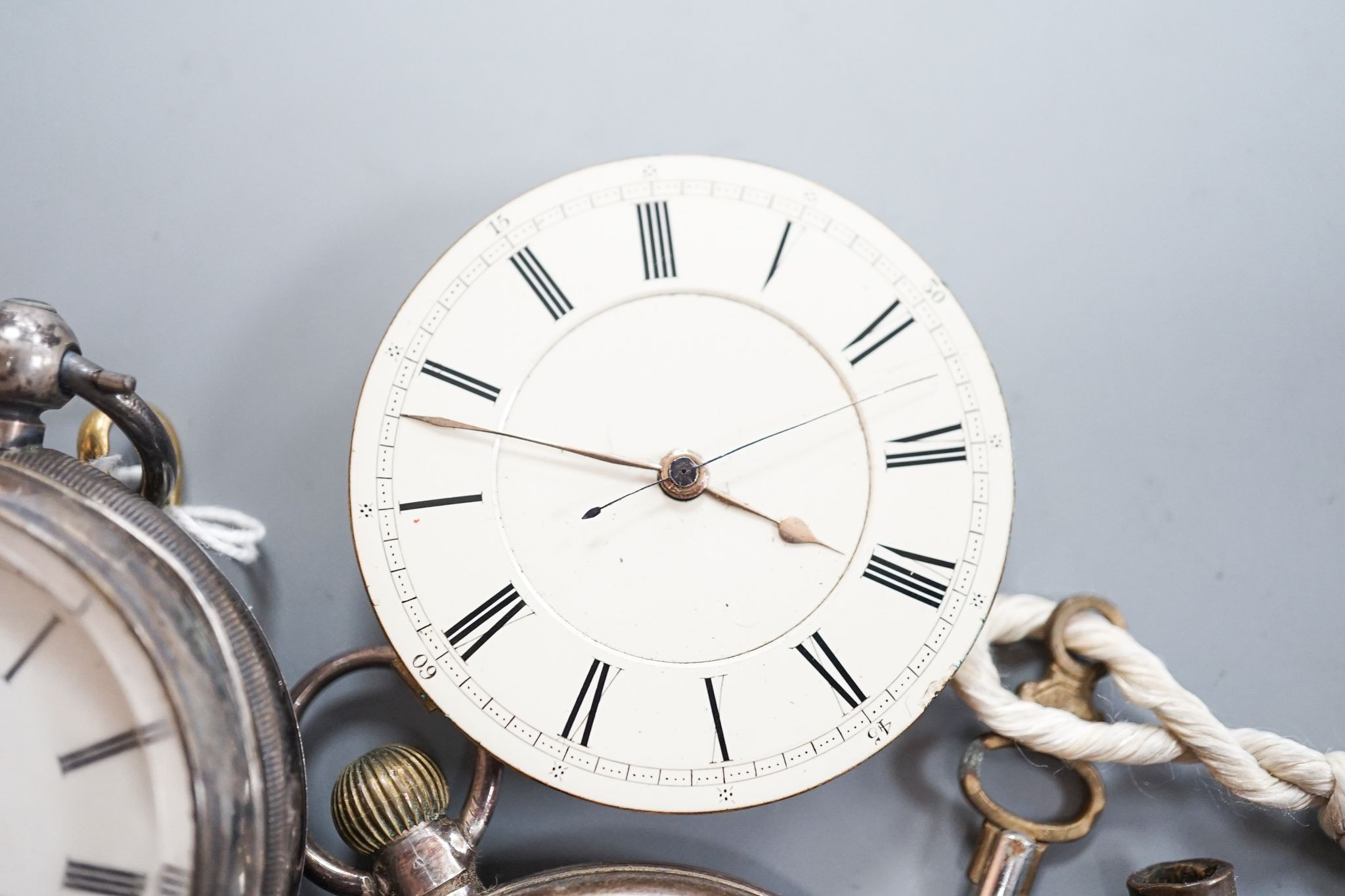 A late Victorian silver keywind open faced pocket watch, retailed by Cornish, Oakehampton, one other silver pocket watch and a pocket watch movement.